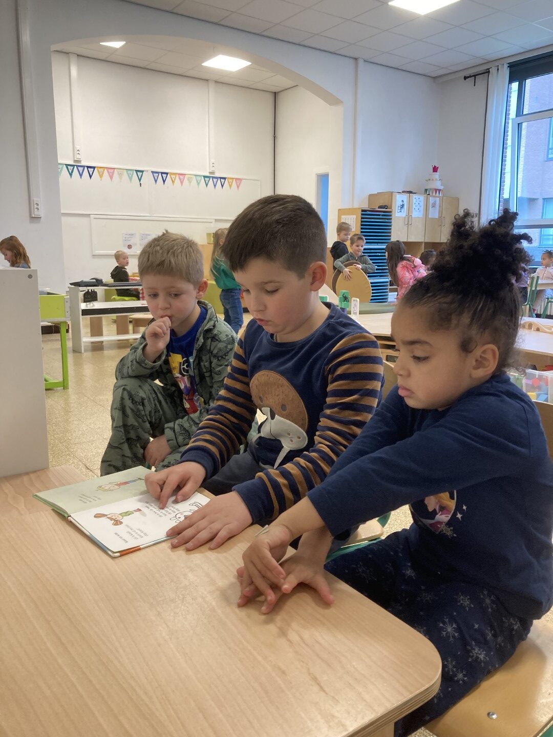Eersteklassers lezen voor in de kleuterschool